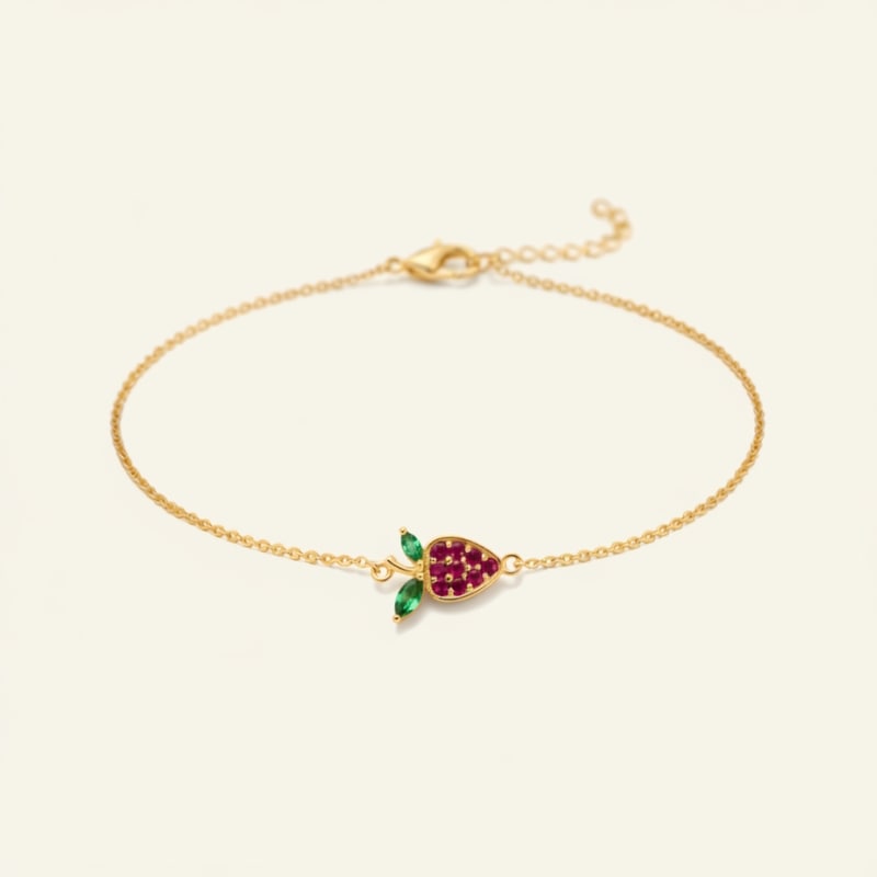 Gold bracelet with a fruit charm on a beige background